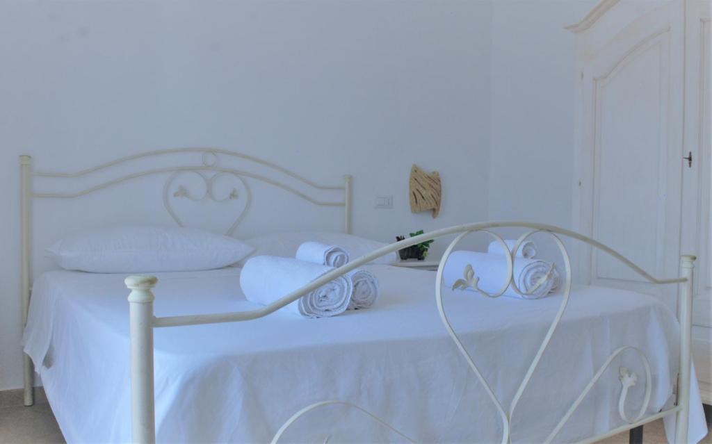 uma cama branca com lençóis e almofadas brancos em I 7 Peccati em Marina di Mancaversa