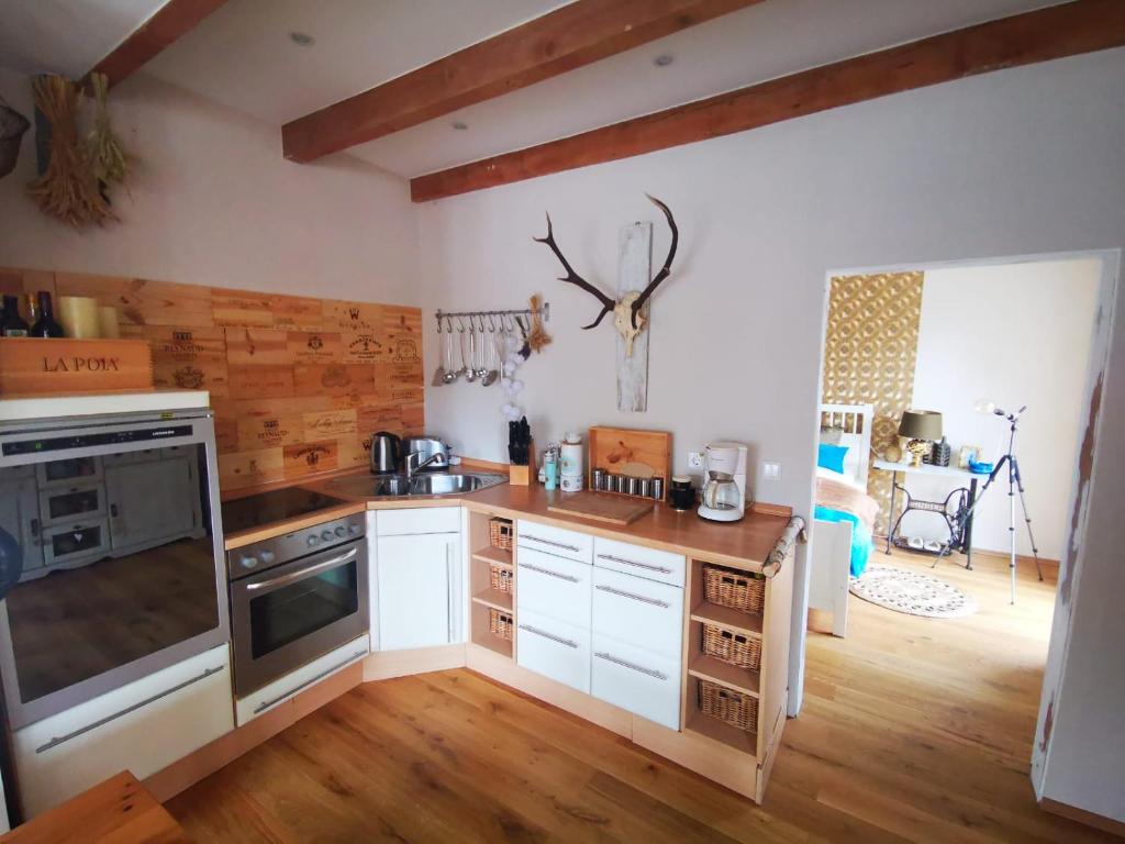 a kitchen with white cabinets and a wooden floor at Ferienwohnung Sternstube De Luxe in Bad Harzburg