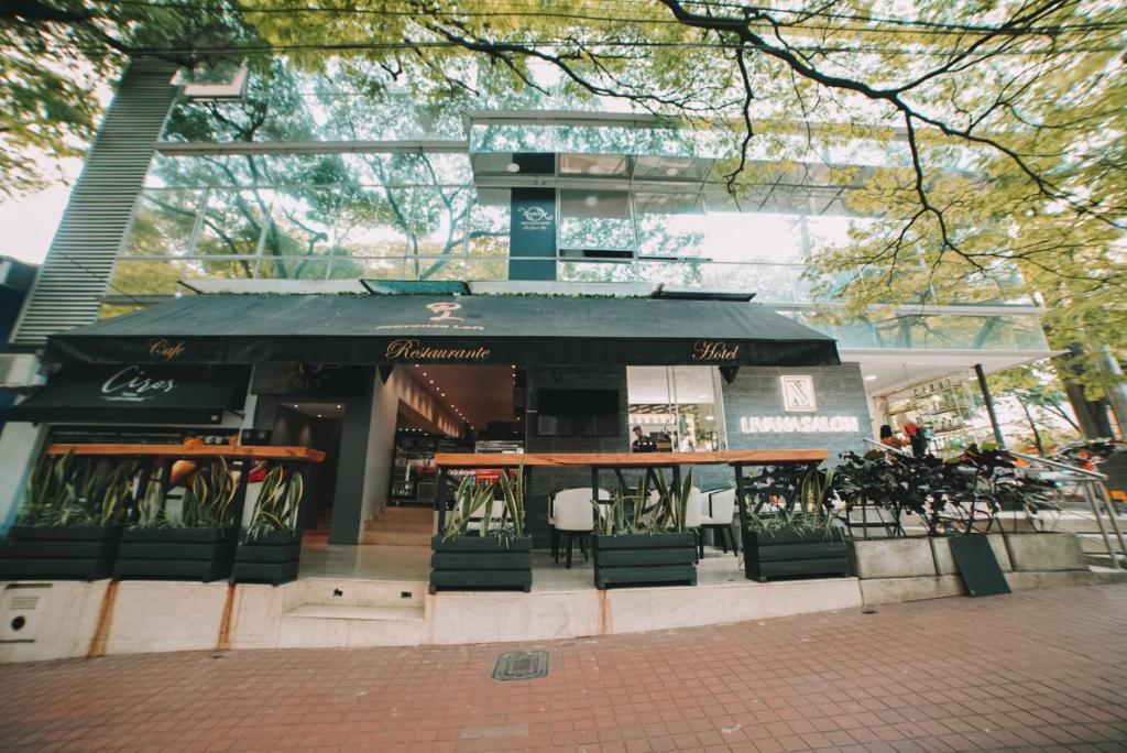 a restaurant with a black awning in front of a building at Provenza Lofts in Medellín