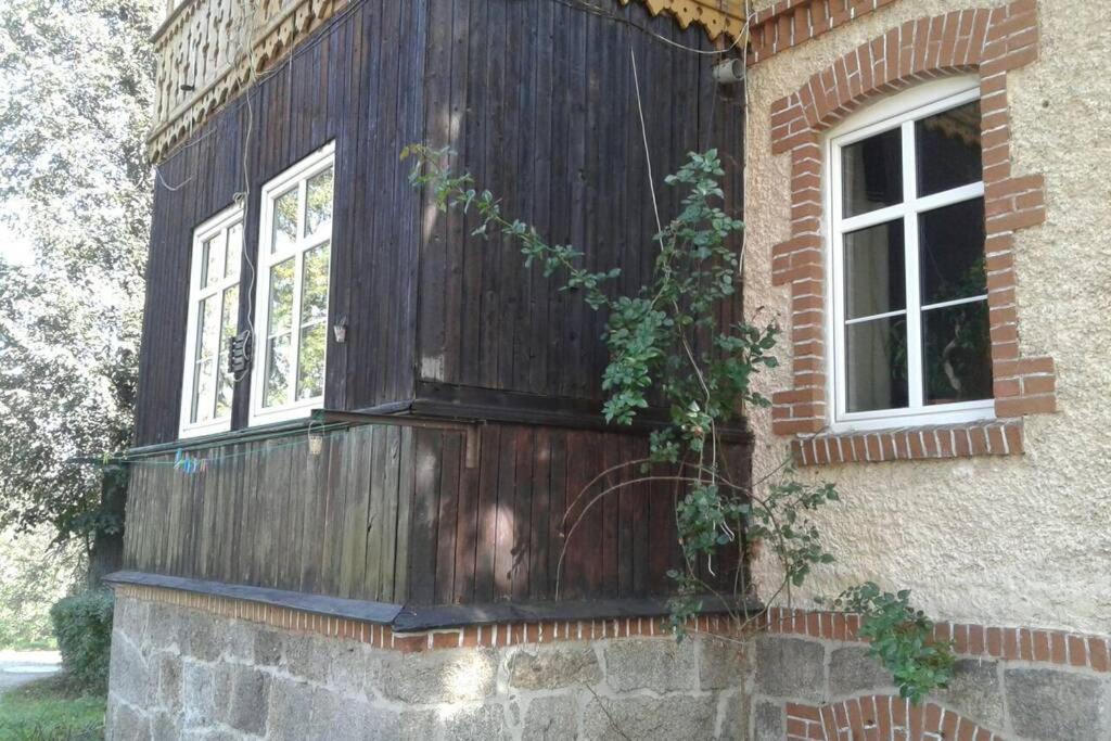 a wooden wall on the side of a building with two windows at KARPACZ SKALNY in Karpacz