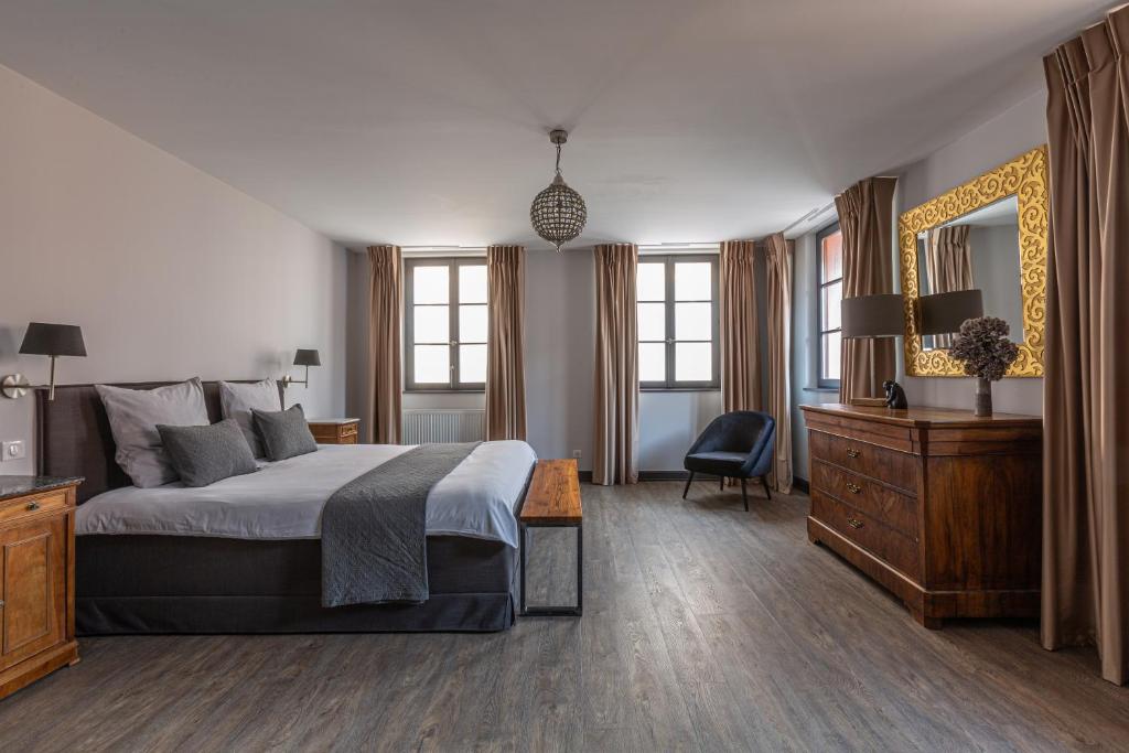 um quarto com uma cama, uma cómoda e um espelho em LA FERME D'ELISA em Epfig