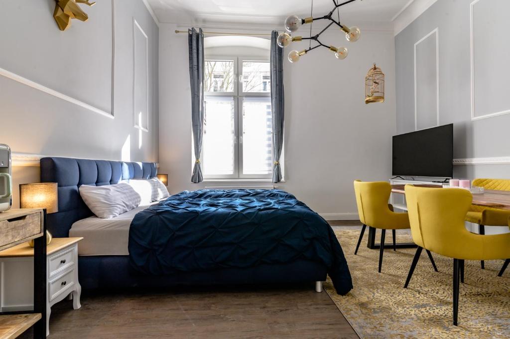 a bedroom with a blue bed and a desk at Downtown Apartments Bilk in Düsseldorf