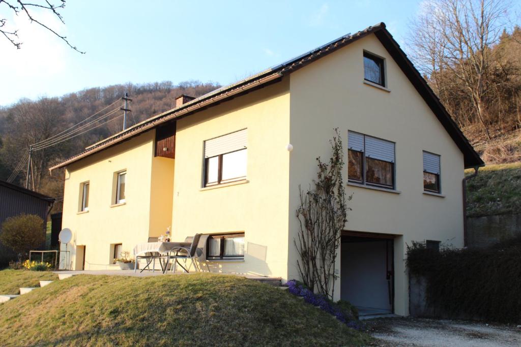 Casa grande de color blanco y amarillo con patio en Ferienhaus am Klosterhof, en Immendingen