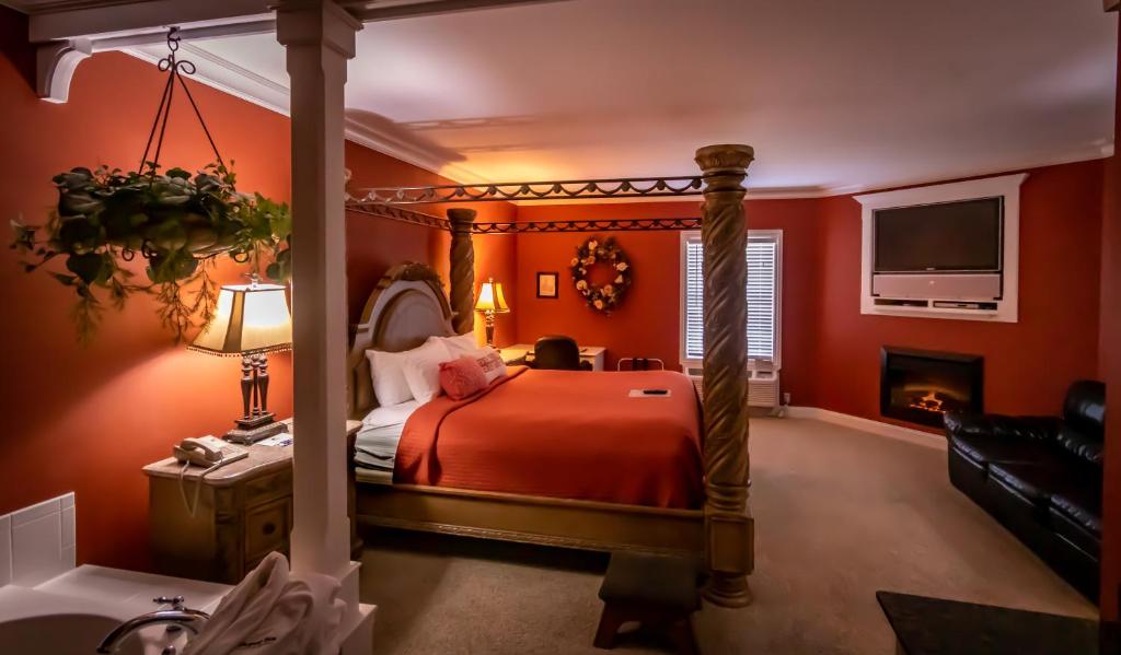 a red bedroom with a bed and a fireplace at Depot Inn & Suites in La Plata