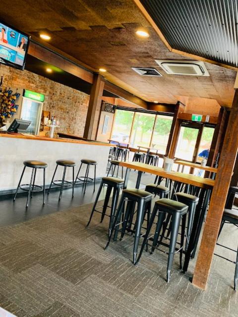 a bar in a restaurant with stools at a counter at Caledonian Hotel Motel in Hamilton