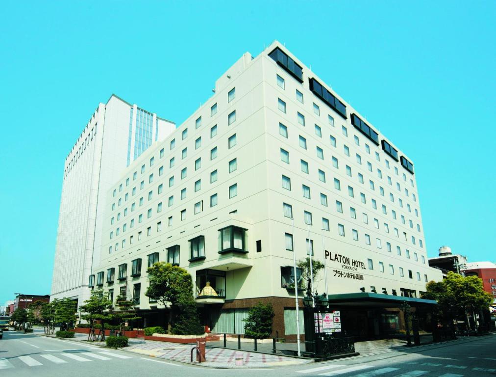 un edificio bianco all'angolo di una strada di Platon Hotel Yokkaichi a Yokkaichi