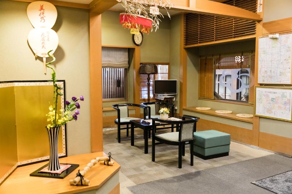 a living room with a table and chairs and a tv at Kyonoyado Kagihei in Kyoto