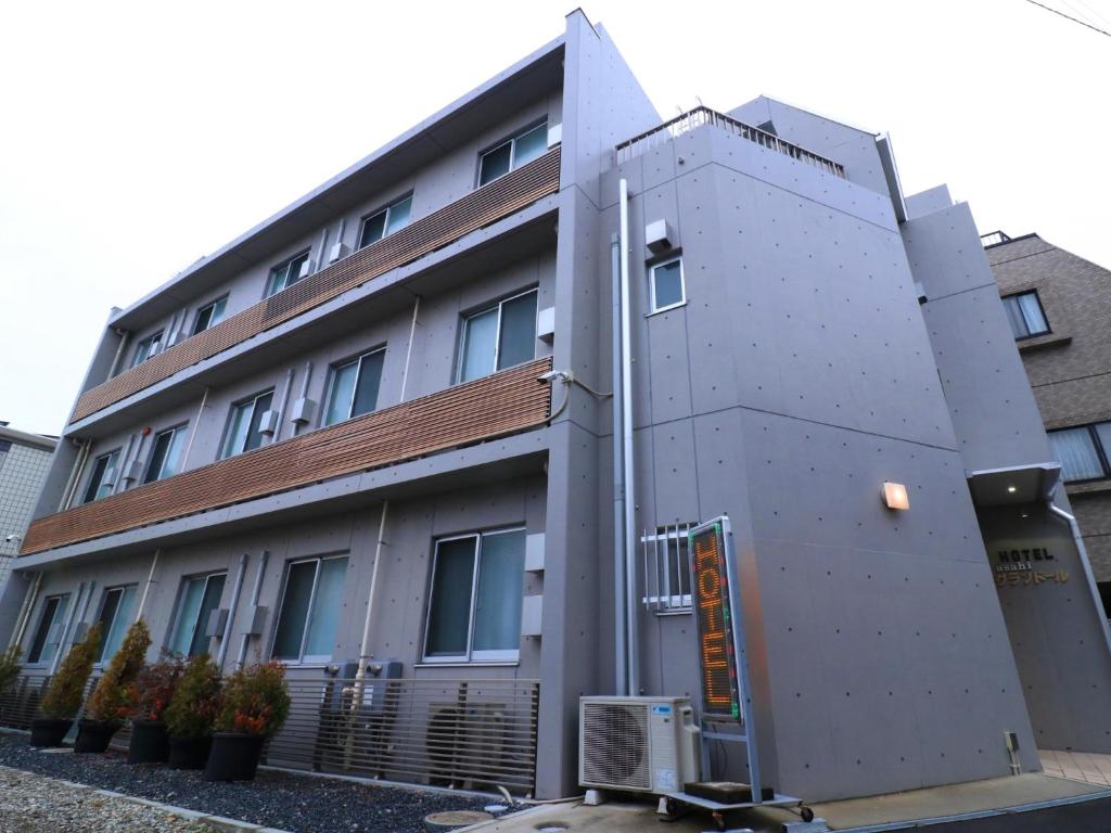 biały budynek z w obiekcie Hotel Asahi Grandeur Fuchu w mieście Fuchū