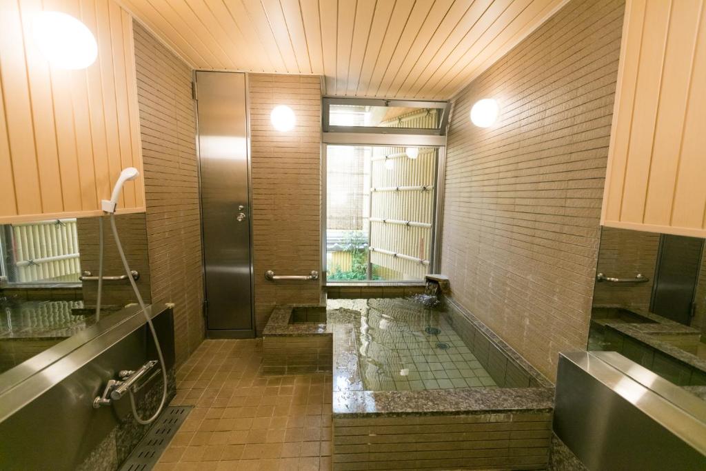 a large bathroom with a shower and a sink at Kyonoyado Kagihei in Kyoto
