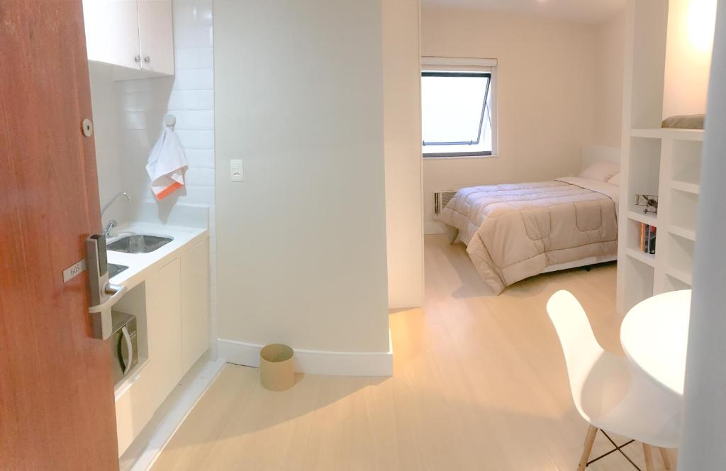 um quarto com uma cama, uma mesa e uma cadeira em Tudo próximo a você em São Paulo