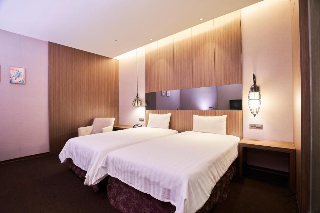 a hotel room with a large bed and two chairs at Hotel Intrendy in Taishan