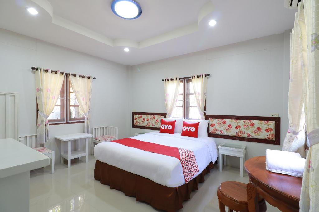 a bedroom with a large bed with red pillows at OYO 553 Kongsup Resort in Lamphun