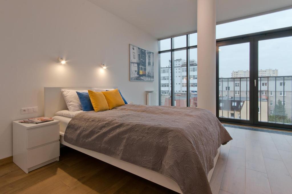 グディニャにあるCITYSTAY Abrahama Gdynia Apartmentのベッドルーム1室(大型ベッド1台、黄色と青の枕付)