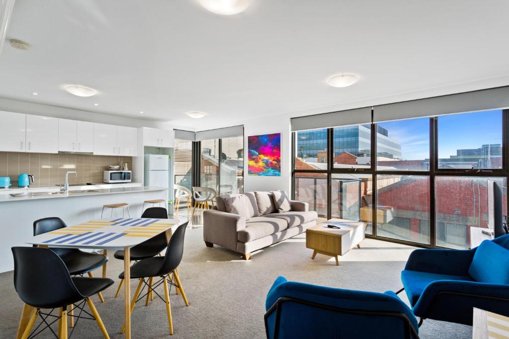 a living room with a table and chairs at Soho 203 in Geelong
