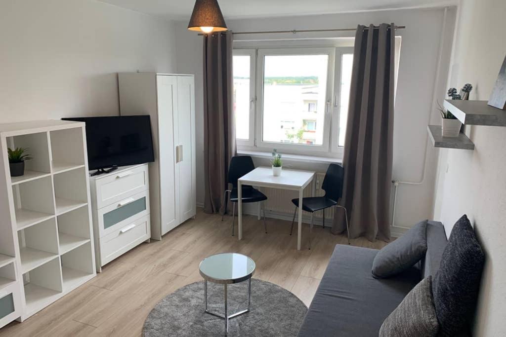 una pequeña sala de estar con sofá y mesa. en 1 Zi-Whg, Netflix, Wifi, Küche, 15min zum Zentrum, en Leipzig