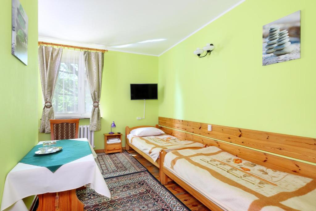 ピアセチュノにあるZajazd Ustronieのベッドルーム1室(ベッド2台、テーブル付)