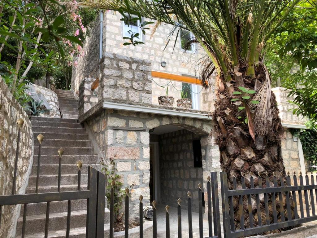 una casa con una puerta y un árbol delante de ella en Villa Masha, en Rijeka Reževići
