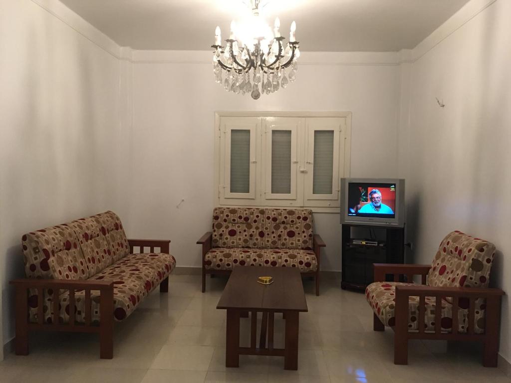 sala de estar con 2 sillas y TV en Nasr City, en El Cairo