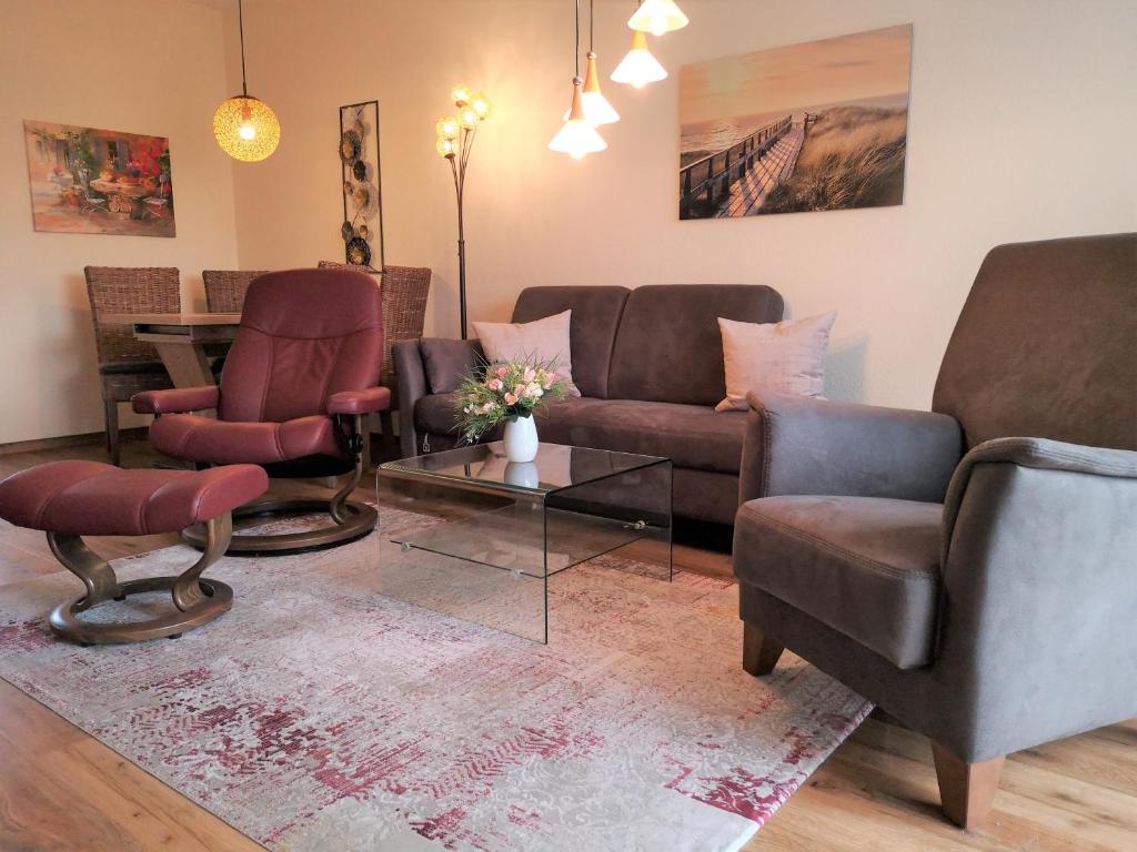 - un salon avec un canapé, des chaises et une table dans l'établissement Appartementhaus Sanssouci, à Kühlungsborn