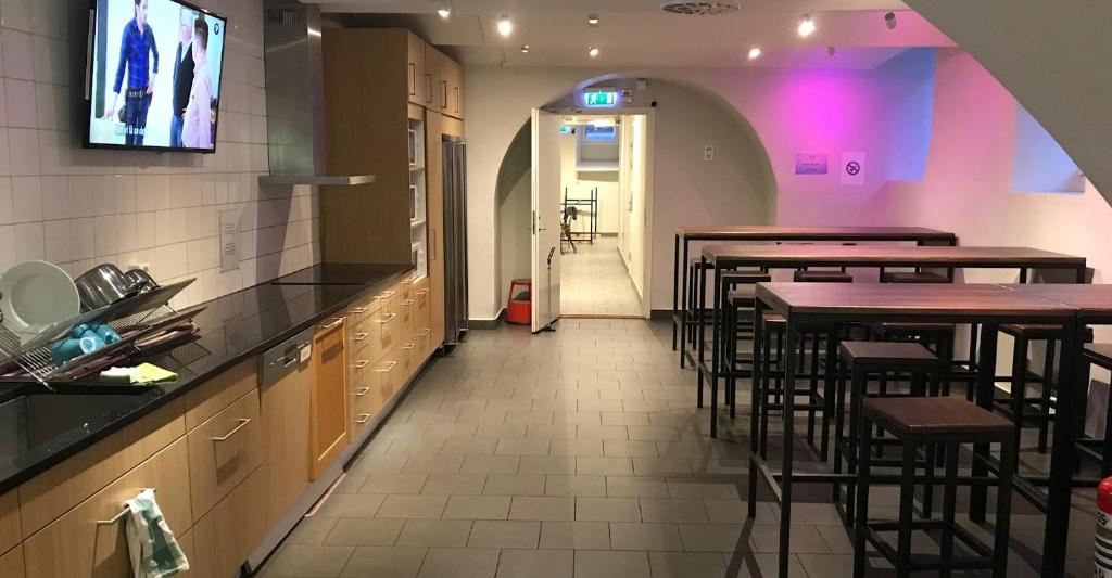 a restaurant with tables and chairs and a tv on the wall at Hostel Dalagatan in Stockholm