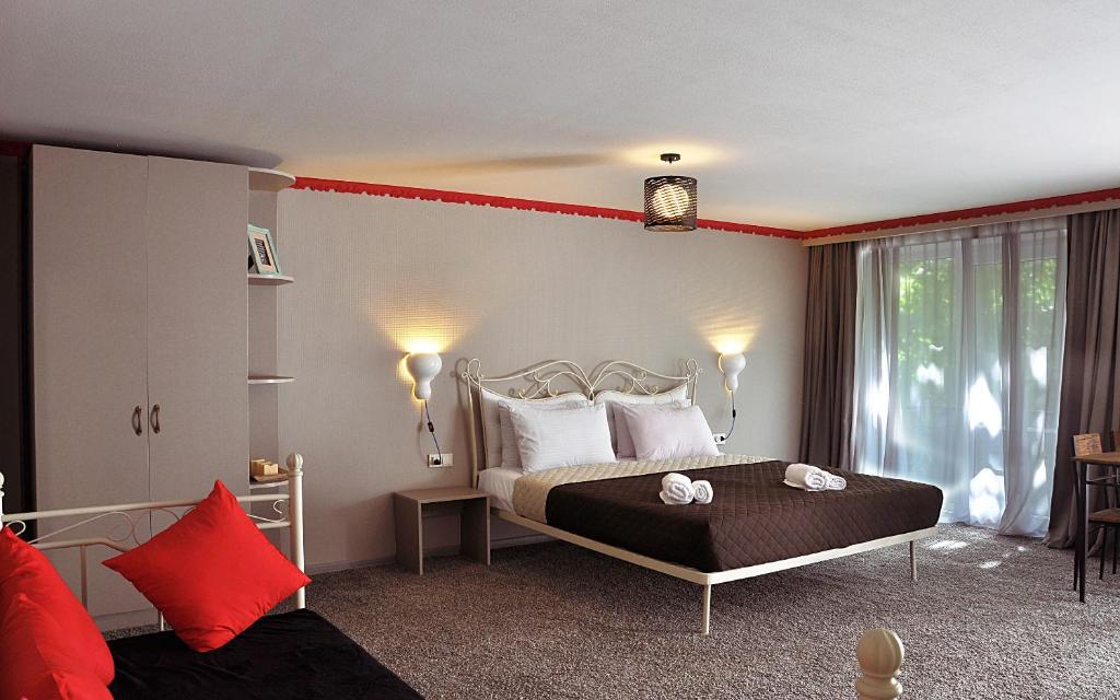 a bedroom with a large bed with red trim at Art Hotel Claude Monet in Tbilisi City