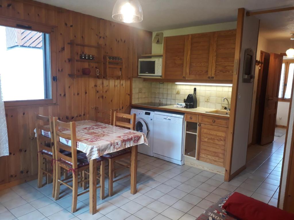 een keuken met een tafel en stoelen en een fornuis bij OURSONS 1 in Morillon