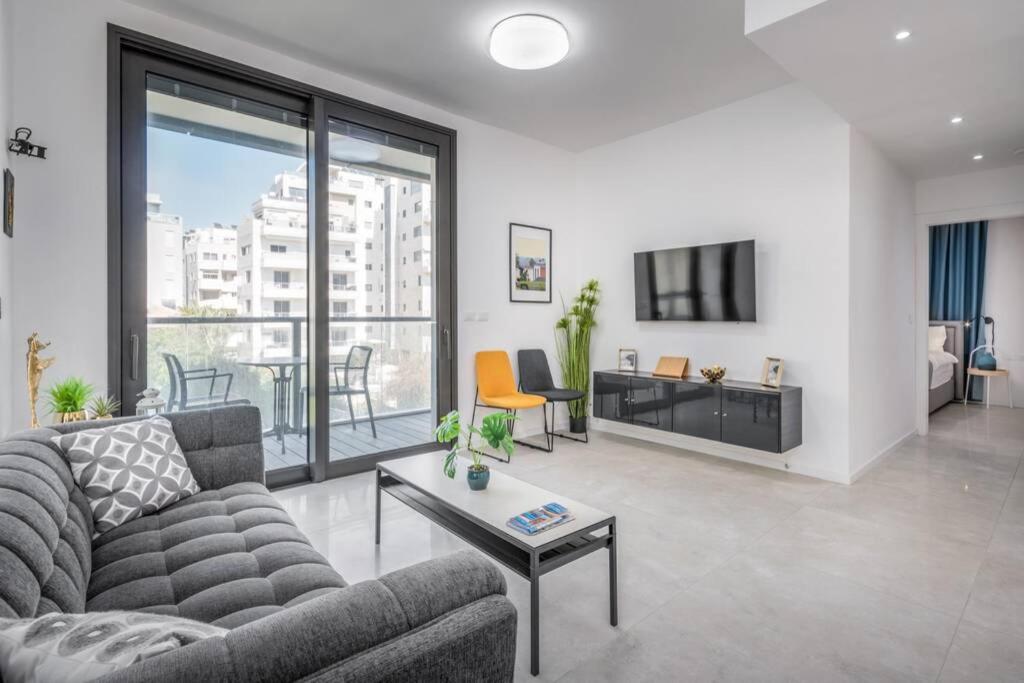 uma sala de estar com um sofá e uma mesa em Kerem Hateimanim Area-3 BR with Balcony em Tel Aviv
