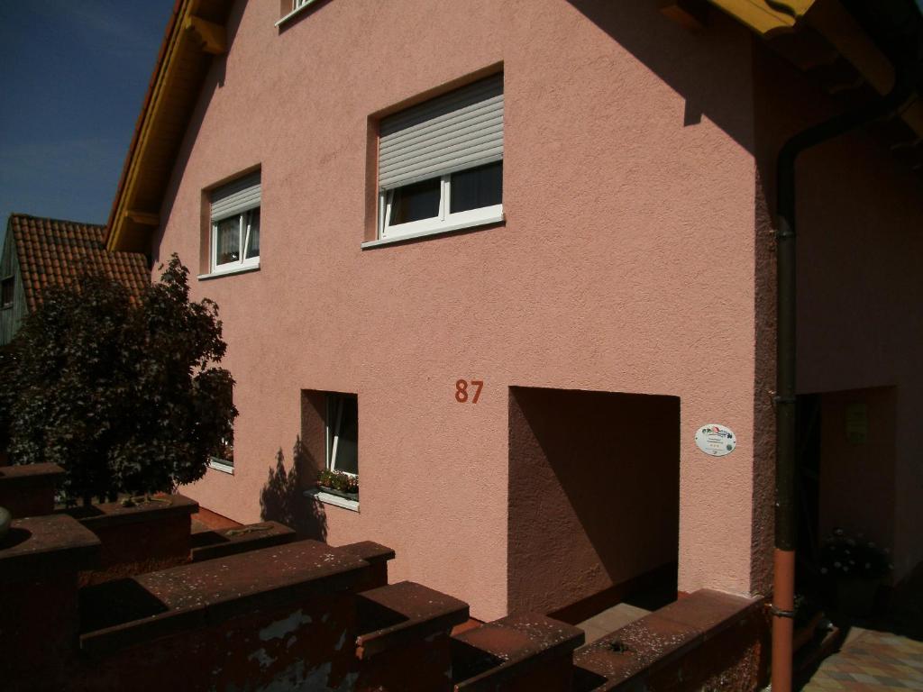 un edificio rosa con un numero di targa sopra di Ferienwohnung Mau a Pirmasens