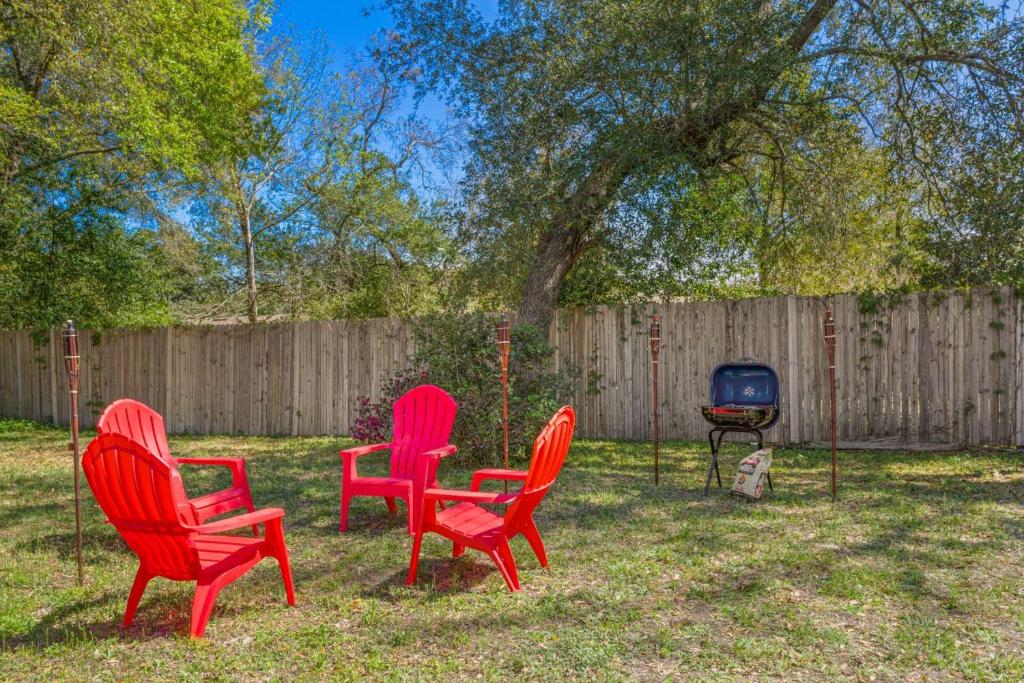 three red chairs and a grill in a yard at Blue Heron in Jacksonville