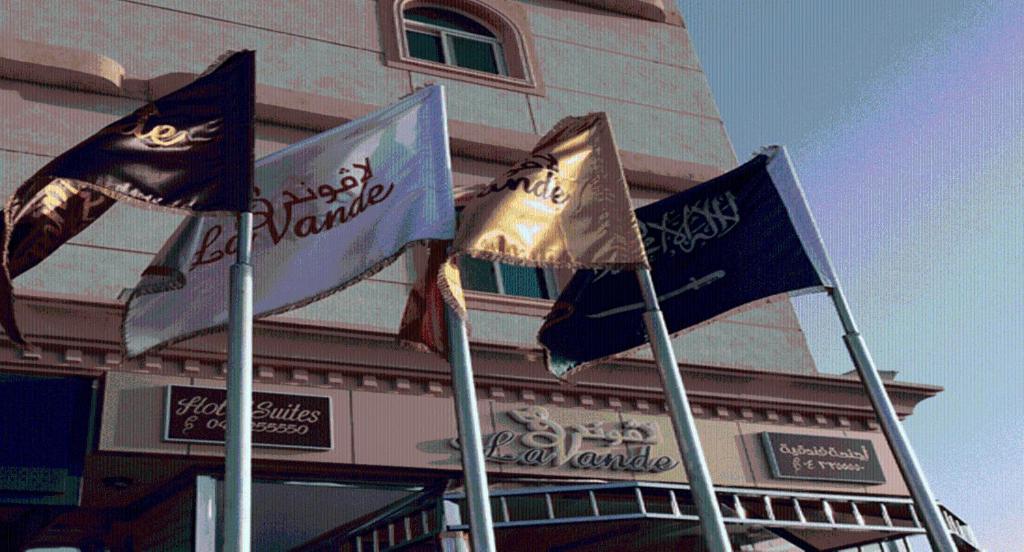 a group of flags in front of a building at Lavande Suites in Yanbu