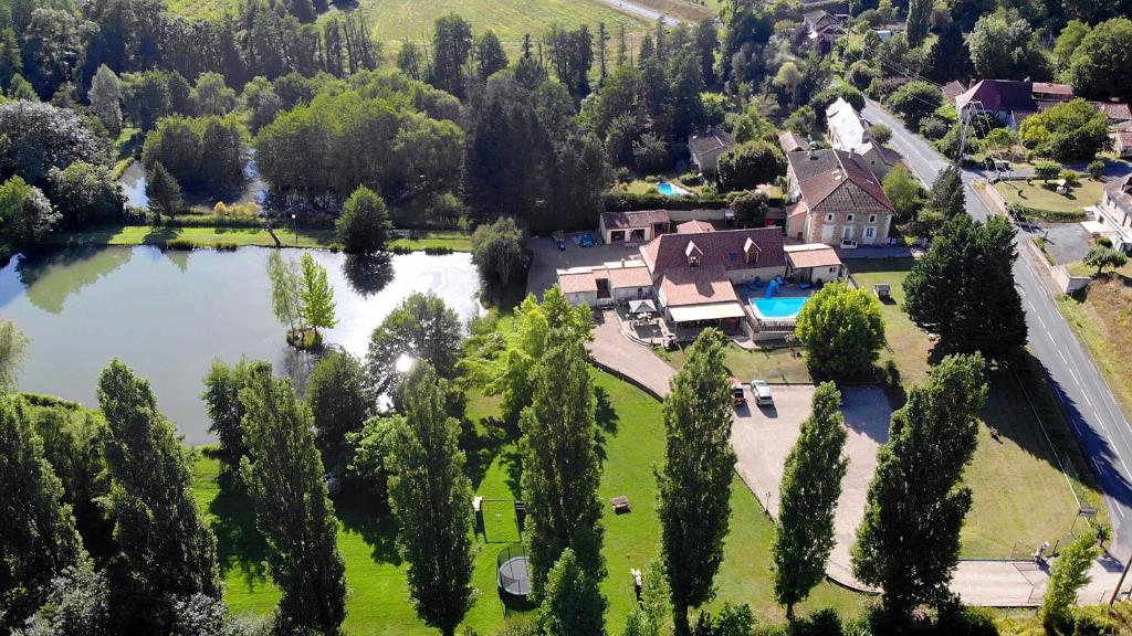 - une vue aérienne sur une maison avec un lac dans l'établissement Les Gites de l'Etang de Sandanet, à Issac