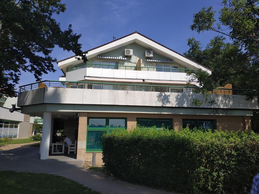 a house with a balcony on top of it at Apartmány Puerto in Senec