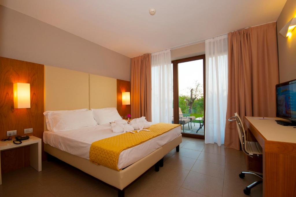 A bed or beds in a room at Eurocongressi Hotel