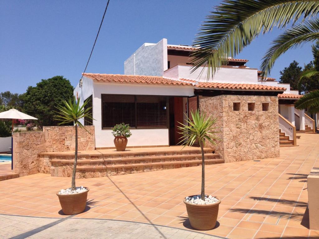 a house with two palm trees in front of it at APARTAMENTS BLAU MAR in Playa Migjorn