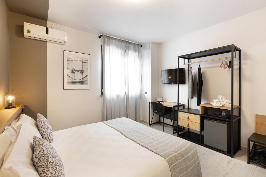 Un dormitorio con una cama, un escritorio y un espejo. en Attico43 B&B, en Florencia