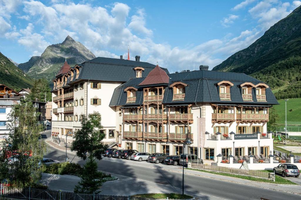 a large building on the side of a street at Alpenresort Fluchthorn in Galtür