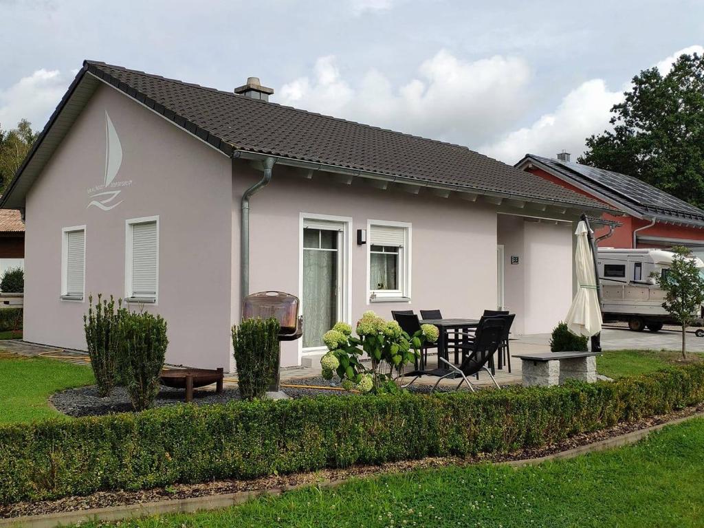 a white house with a table and a patio at Haus Brückelsee in Wackersdorf