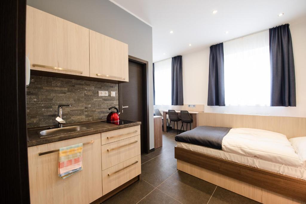 een slaapkamer met een bed en een wastafel in een kamer bij Apartments Danube in Bratislava