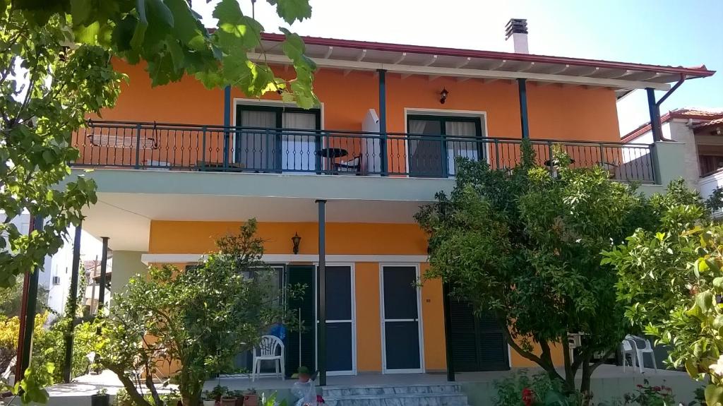 an orange and white house with a balcony at Orange Tree Garden in Pefkochori