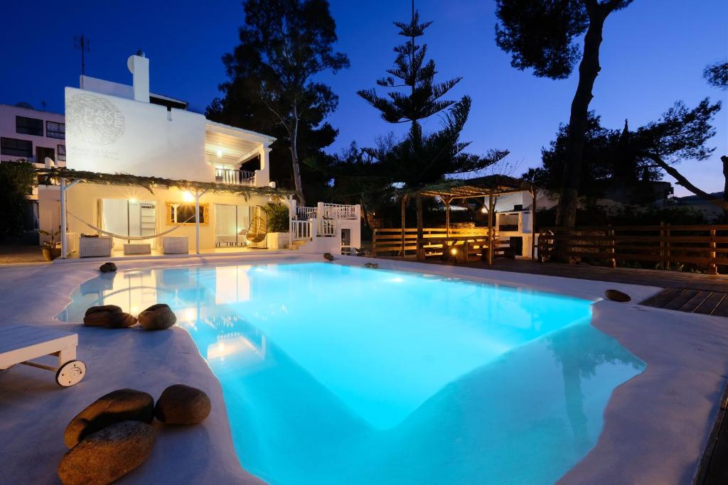 ein Schwimmbad in der Nacht mit einem Haus im Hintergrund in der Unterkunft Villa Clara Ibiza in Santa Eulària des Riu