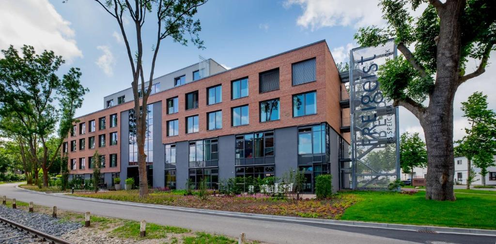 an office building on a street with trees at Hotel FREIgeist Einbeck BW Signature Collection in Einbeck