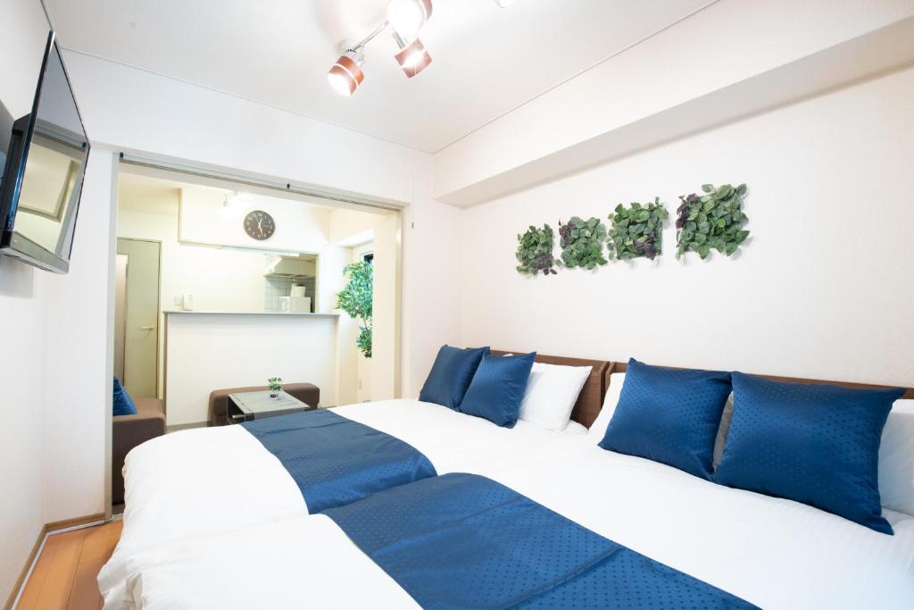 une chambre avec un grand lit avec des oreillers bleus dans l'établissement Elizabeth Garden II, à Osaka