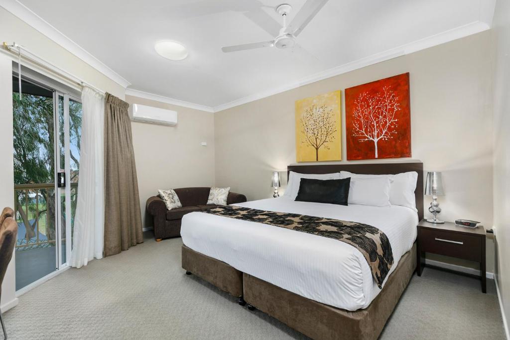 1 dormitorio con 1 cama grande y 1 sofá en Best Western Kimba Lodge en Maryborough