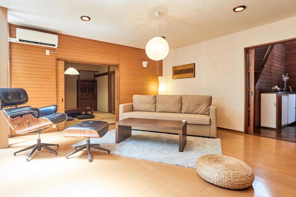 - un salon avec un canapé, une table et des chaises dans l'établissement Villa Shibuya, à Tokyo