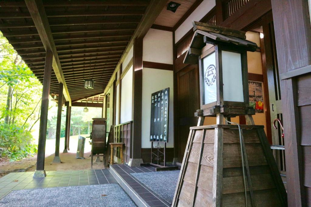 een veranda van een gebouw met een klok erop bij Bunanoyado Koase in Aga