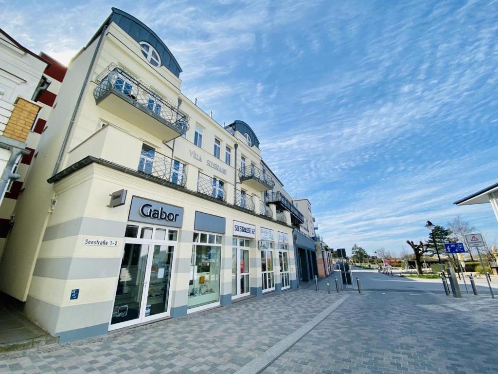 a building on a street with a blue sky at Ostseeliebe, direkt an der Promenade in Warnemünde