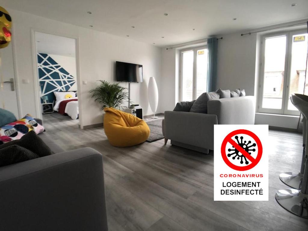 ein Wohnzimmer mit Sofa und ein Schild, auf dem unbequeme Möbel stehen in der Unterkunft La Suite Emoji - SDP in Lagny