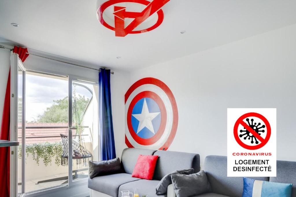 uma sala de estar com um sofá e um escudo na parede em Super Hero Suite - SDP em Serris