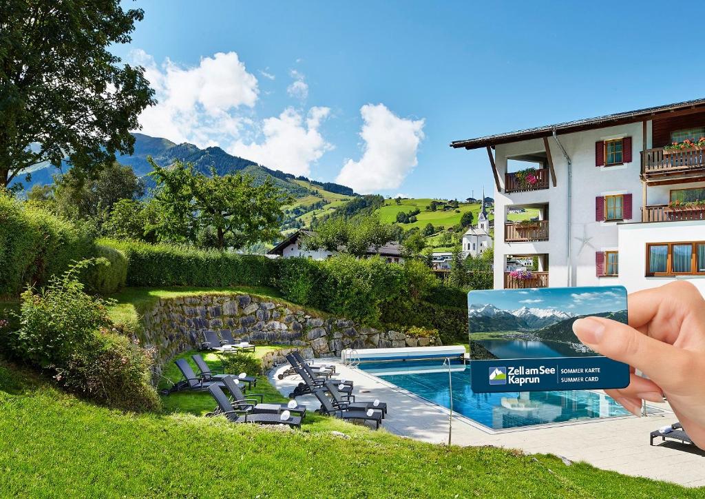 una persona che scatta una foto di un hotel di Das Alpenhaus Kaprun inkl Zell am See-Kaprun Sommerkarte a Kaprun
