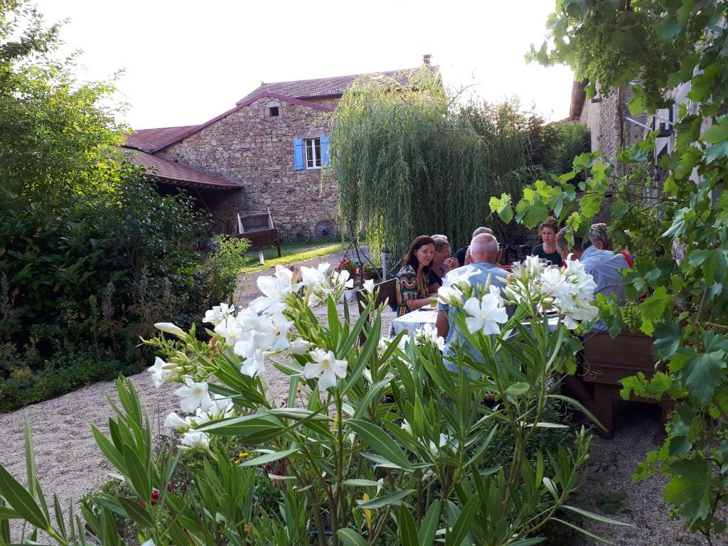 un groupe de personnes assises à une table dans un jardin dans l'établissement Le Vertige, à Échandelys